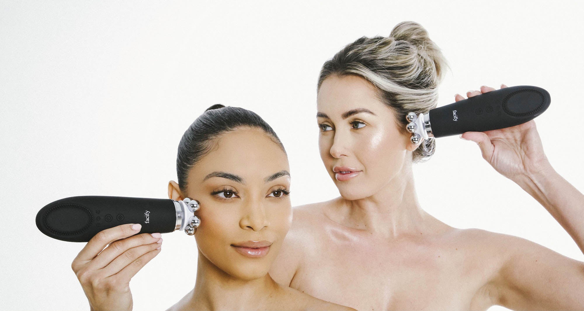 two women using the facify beauty wand device on their face